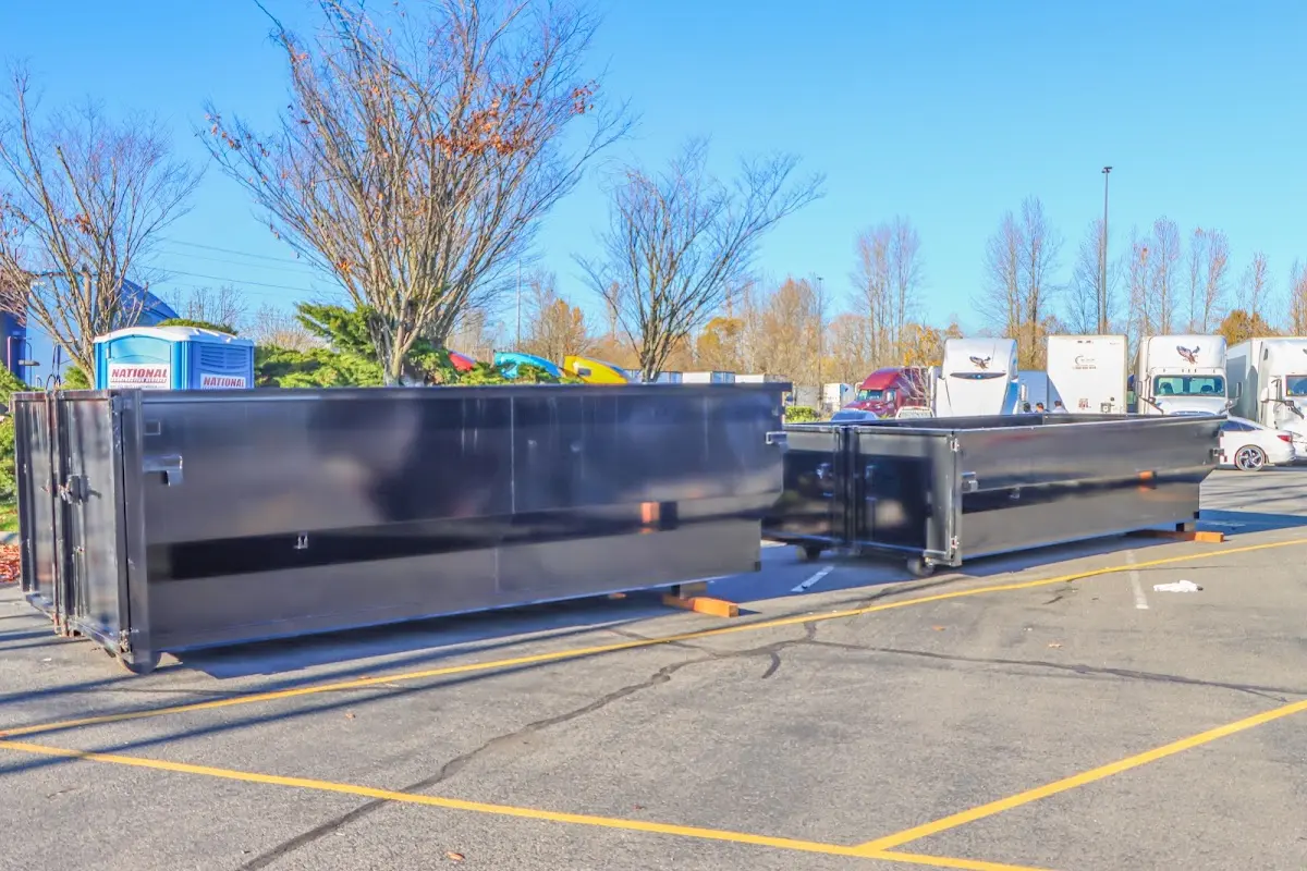 Professional dumpster rental service with roll-off container on residential driveway in Le Ray